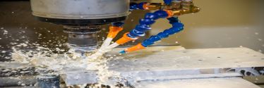 Lubricant is sprayed over a metal plate during the drilling process